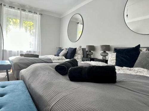 a white room with two beds and a mirror at Balcony Apartment, 1 min to U1 Reumannplatz in Vienna