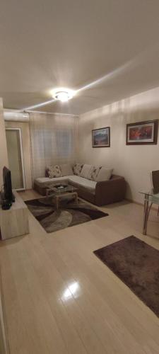 uma sala de estar com um sofá e uma mesa em Beko City em Podgorica