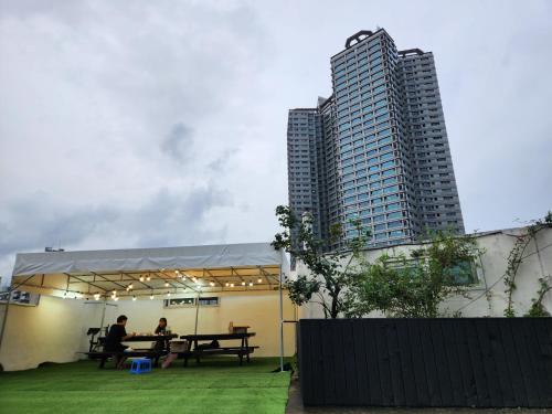 two people sitting at a picnic table in front of a tall building at k histay jongan in Seoul