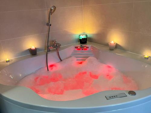 a bath tub filled with red dye with candles at LA BADINE 5p Plage piscine clim jacuzzi parc luxuriant in Hyères