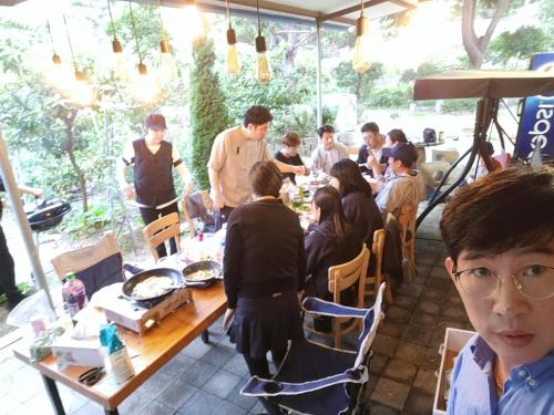 um grupo de pessoas sentadas numa mesa num restaurante em K Highstel Jayeon 
