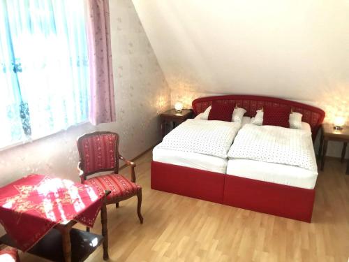 1 dormitorio con 1 cama roja y 1 silla en Room in Apartment - Haus Im Grunen House in the green, en Neuzelle