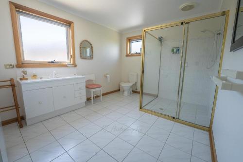 a bathroom with a shower and a sink at Kiama Cottage beside the Bay in St Helens
