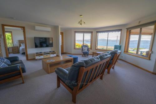 a living room with a couch and a tv at Kiama Cottage beside the Bay in St Helens