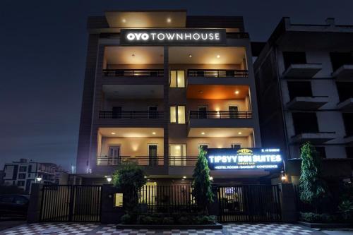 um edifício alto com um cartaz à noite em Townhouse Sector Near Bestech Central Square Mall em Gurgaon