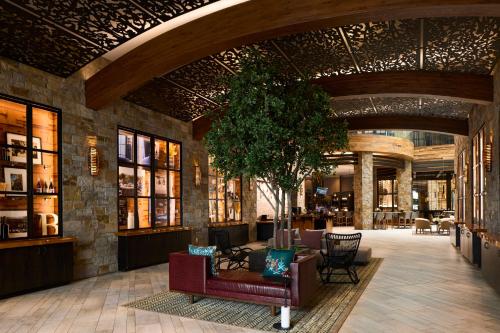a lobby with couches and a tree in a building at Archer Hotel Napa in Napa