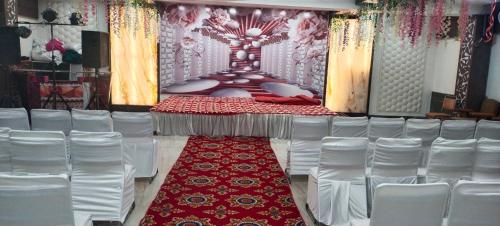 eine Bühne mit rotem Teppich und weißen Stühlen in der Unterkunft HOTEL EMPIRE&BANQUET in Hisār