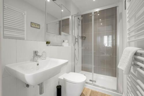 a bathroom with a sink and a toilet and a shower at Foxherne 5BDR 3BA Serviced House with Parking - Slough By 360Stays in Slough