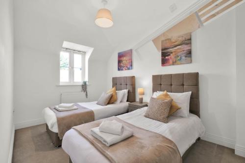 Duas camas num quarto com paredes brancas em Foxherne 5BDR 3BA Serviced House with Parking - Slough By 360Stays em Slough