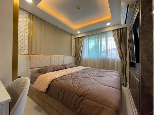 a bedroom with a large bed and a window at Room at Pattaya, Jomtien Beach in Jomtien Beach