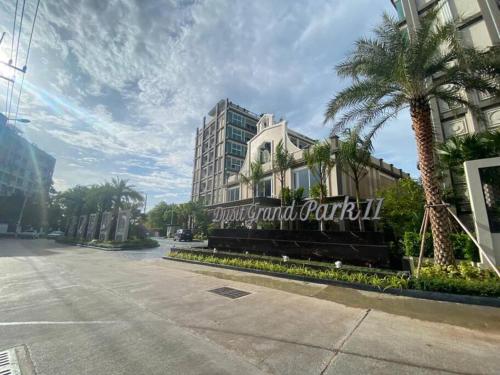 a sign for a hotel on a street with palm trees at Room at Pattaya, Jomtien Beach in Jomtien Beach