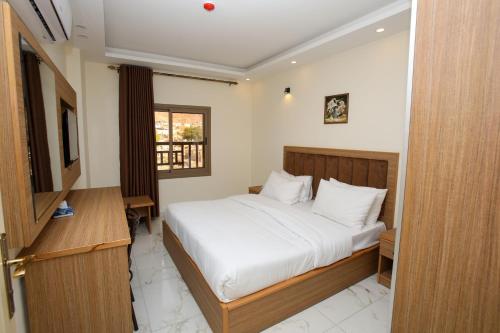 アカバにあるAl Sadrah View Hotel-فندق اطلالة السدرةのベッドルーム1室(白いシーツ付きのベッド1台、窓付)