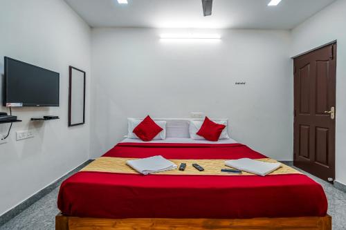 a bedroom with two beds and a flat screen tv at French Park Inn in Puducherry