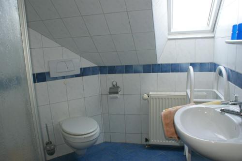 a bathroom with a toilet and a sink at Haus Kuhn in Carolinensiel