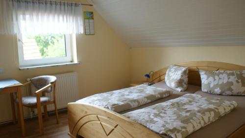 a bedroom with a bed and a desk and a window at Haus Kuhn in Carolinensiel