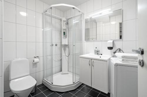 a bathroom with a shower and a toilet and a sink at Enter Amalie Apartment Hotel in Tromsø