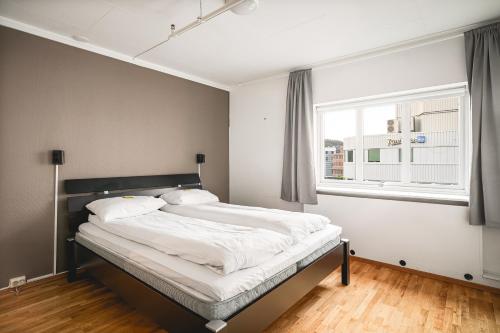 a bedroom with a large bed with a window at Enter Amalie Apartment Hotel in Tromsø