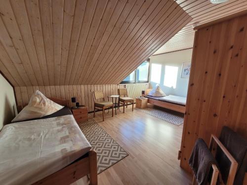 a bedroom with a wooden ceiling with a bed and a table at Eifelferienhaus Thome - a34701 in Lissendorf