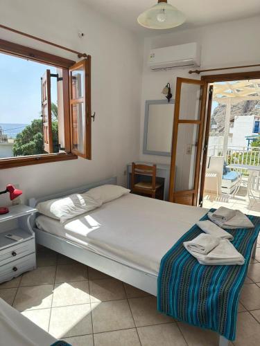 a bedroom with a bed and a window with a view at Panorama Zimmer und Apartments Lentas in Léntas