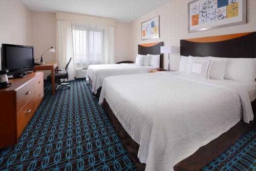 a hotel room with two beds and a television at Fairfield Inn & Suites by Marriott Dallas Plano The Colony in The Colony