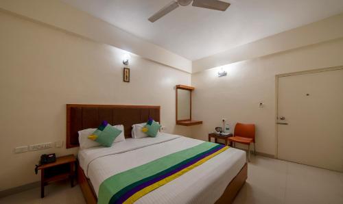 a bedroom with a large bed with a colorful blanket at Treebo Sam Residency in Coimbatore