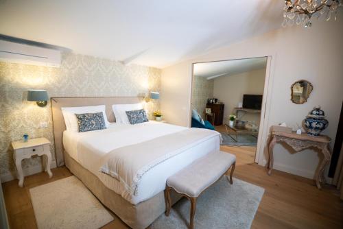 a bedroom with a large bed and a mirror at Chateau Pont Saint-Martin in Léognan