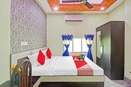 a bedroom with a bed with red pillows at Collection O 87025 Pink House in Madhyamgram