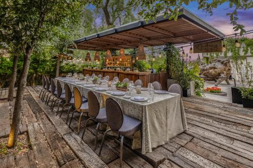 a long table with chairs in a garden at Live Aqua San Miguel de Allende in San Miguel de Allende