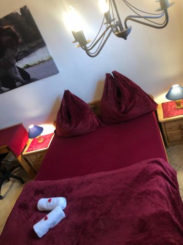 a red bed with two white towels on it at Hundeurlaub im Tiny House im Wald in Tanna