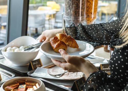 a person sitting at a table with a plate of food at Première Classe Lyon Centre Gare Part Dieu in Lyon