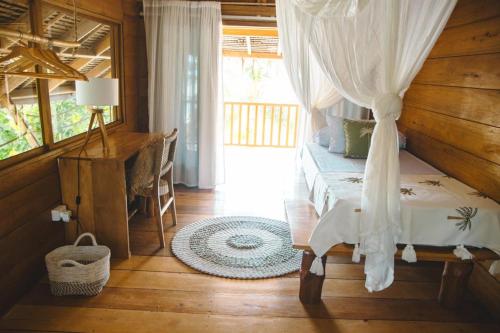 a bedroom with a bed and a desk in a room at Favela Mentawai in Tua Pejat