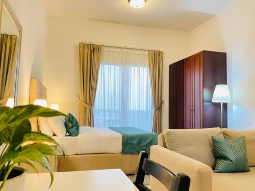 a hotel room with a bed and a couch at Hala Holiday Homes - Al Hamra Village, RAK in Ras al Khaimah
