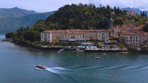 a boat in the water in front of a city at Grand Hotel Villa Serbelloni in Bellagio