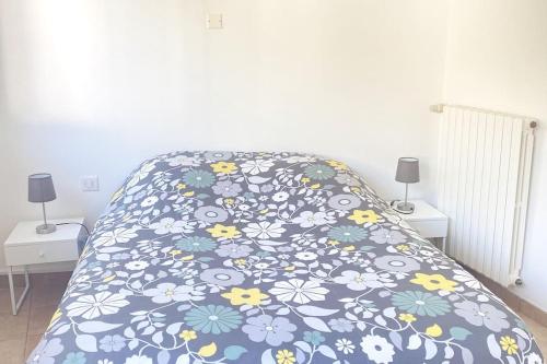 uma cama com um cobertor azul com flores em Au coeur du Croisic notre havre de paix em Le Croisic