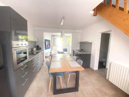 une cuisine avec une grande table et des chaises en bois dans l'établissement Au coeur du Croisic notre havre de paix, au Croisic