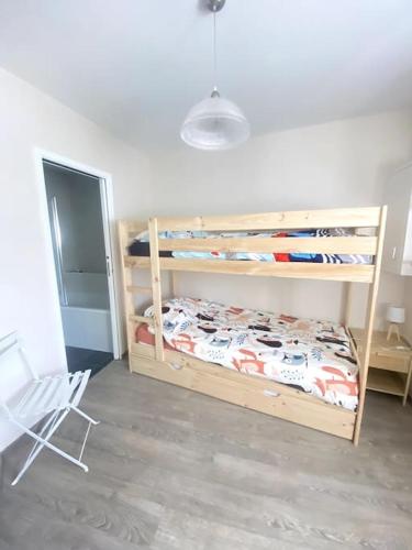 - une chambre avec 2 lits superposés et une chaise dans l'établissement Au coeur du Croisic notre havre de paix, au Croisic