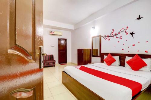 a bedroom with a large bed with red pillows at Collection O Sabharwal Inn in Bangalore