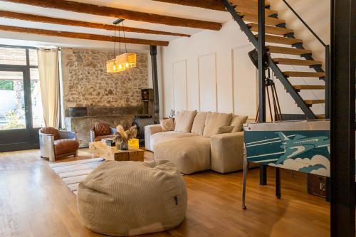 un salon avec un canapé et un escalier dans l'établissement Le Mas Lafleur - Charmant Mas provençal, à Châteaurenard