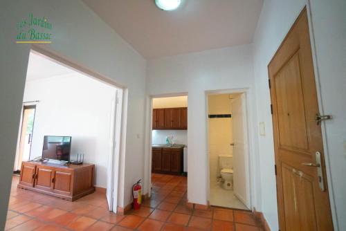 a room with a bathroom with a toilet and a television at Les Jardins Du Bassac in Phnom Penh