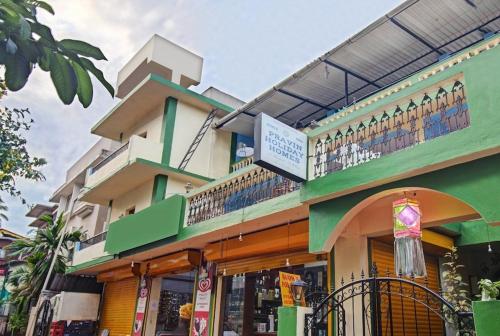 Super OYO Pravin Holiday Homes في كالانغيُت: مبنى أخضر مع شرفة فوقه