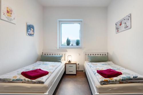 2 camas individuales en una habitación con ventana en Speicherhäuschen Maike, en Geeste