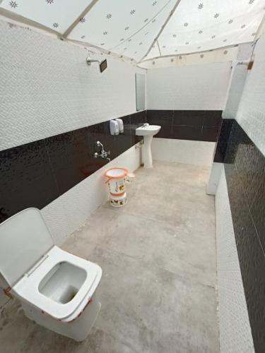 a bathroom with a toilet and a sink at Barkha Desert Safari Camp Sam Sand Dunes Jaisalmer in Sām