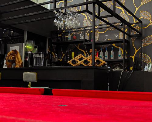 a bar with a red carpet and a red counter at Hotel Dafam Pekanbaru in Pekanbaru