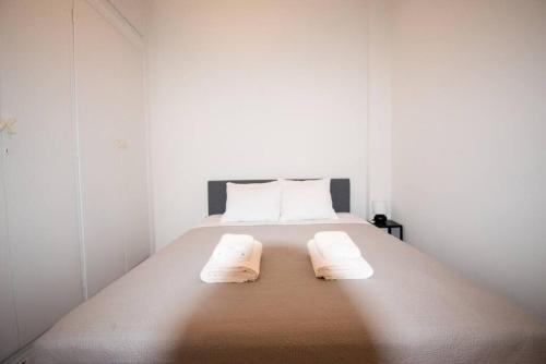 a bedroom with a bed with two towels on it at Chic Kastella Apt by Mikrolimano in Piraeus