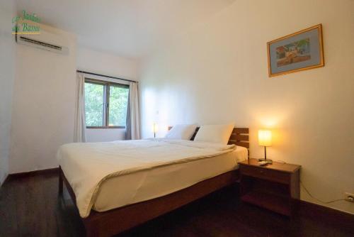 a bedroom with a large bed and a window at Les Jardins Du Bassac in Phnom Penh