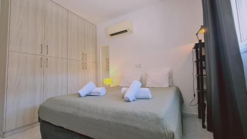 um quarto branco com uma cama com almofadas brancas em STAY W Apartment em Limassol