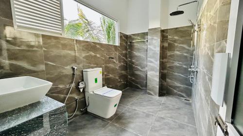 uma casa de banho com um WC, um lavatório e um chuveiro em Salubrious Resort em Anuradhapura
