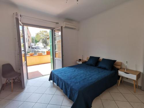 a bedroom with a blue bed and a sliding glass door at Le Glacis in Collioure