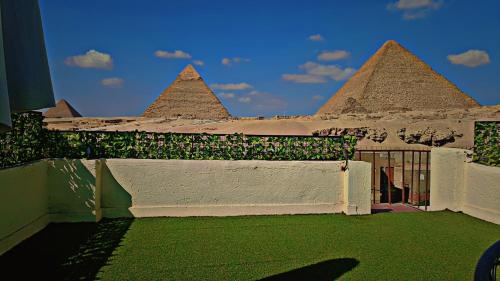 a view of a building with pyramids in the background at Solima Pyramids View in Cairo