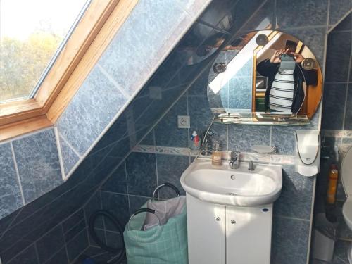 a person taking a picture of a bathroom with a sink at Apartament u Oli in Karpacz